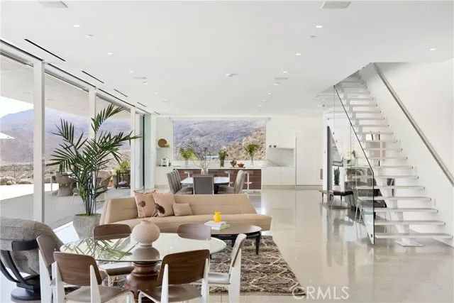 a dining area with furniture and a floor to ceiling window
