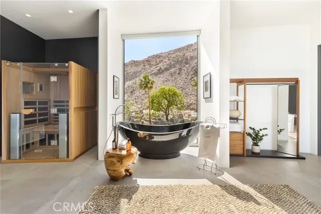 a living room with furniture a rug and a floor to ceiling window