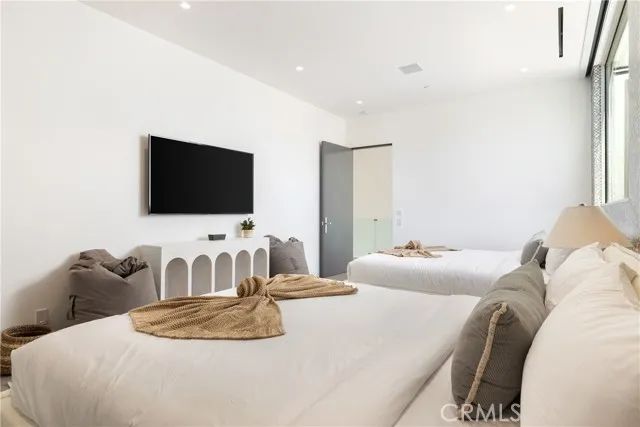 a bedroom with a large bed and a flat screen tv