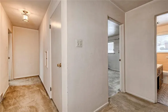a view of an empty room with a fireplace and a window