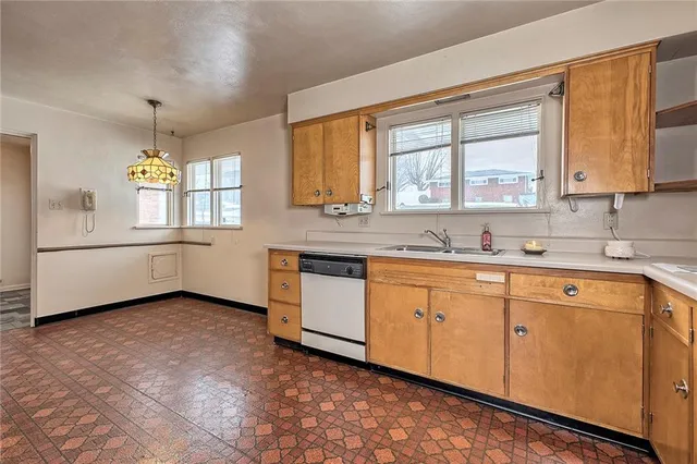 a kitchen with granite countertop a sink window and cabinets