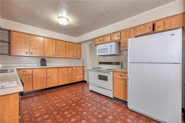 a kitchen with white cabinets and white appliances