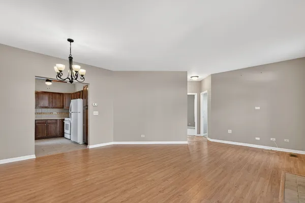 a view of a room with wooden floor fireplace and windows