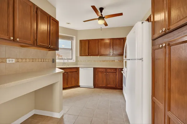 a kitchen with a refrigerator sink and cabinets