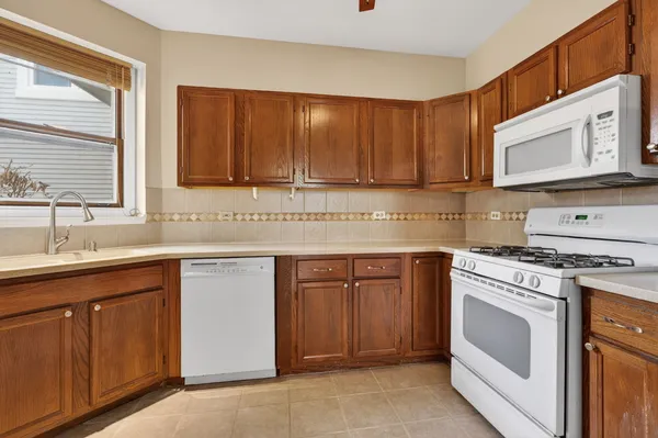 a kitchen with cabinets appliances a sink and a window
