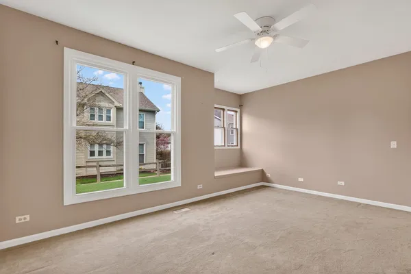 a view of an empty room with a window and a kitchen view