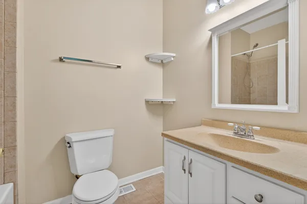 a bathroom with a granite countertop sink a toilet and a mirror