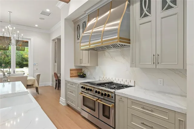 a kitchen with stainless steel appliances granite countertop a stove and a white cabinets