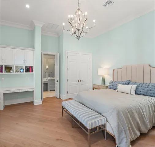 a spacious bedroom with a bed and a chandelier