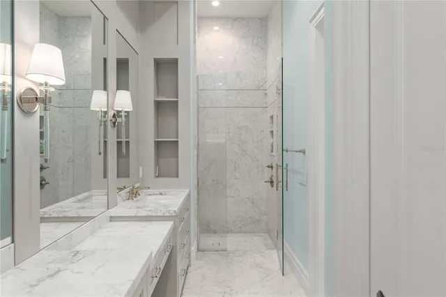 a bathroom with a granite countertop sink mirror and shower