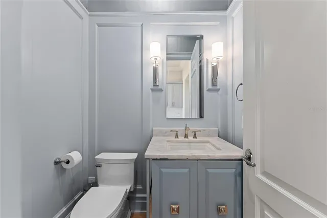 a bathroom with a granite countertop sink toilet and mirror