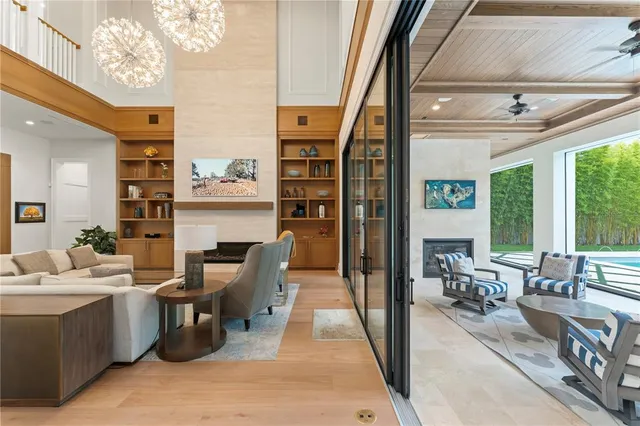a living room with furniture a fireplace and large windows