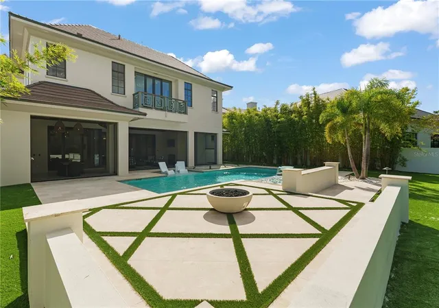 a view of a house with backyard pool and sitting area