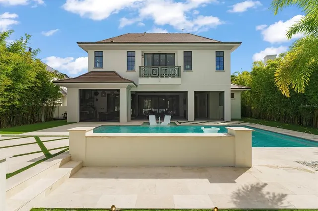 a front view of a house with swimming pool having outdoor seating