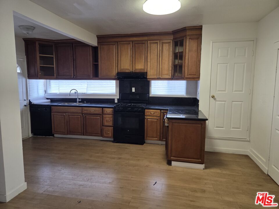1612 Arlington Avenue Los Angeles, CA 90019 - Photo 12 of 24 a kitchen with stainless steel appliances granite countertop a stove a sink and a microwave