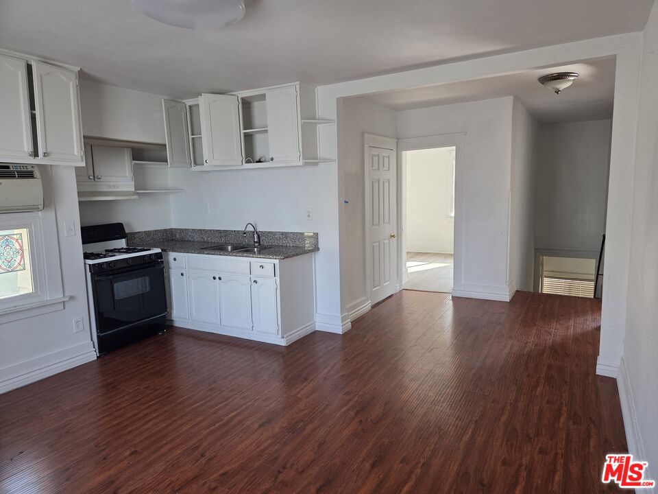 1612 Arlington Avenue Los Angeles, CA 90019 - Photo 18 of 24 a kitchen with granite countertop a sink cabinets and wooden floor