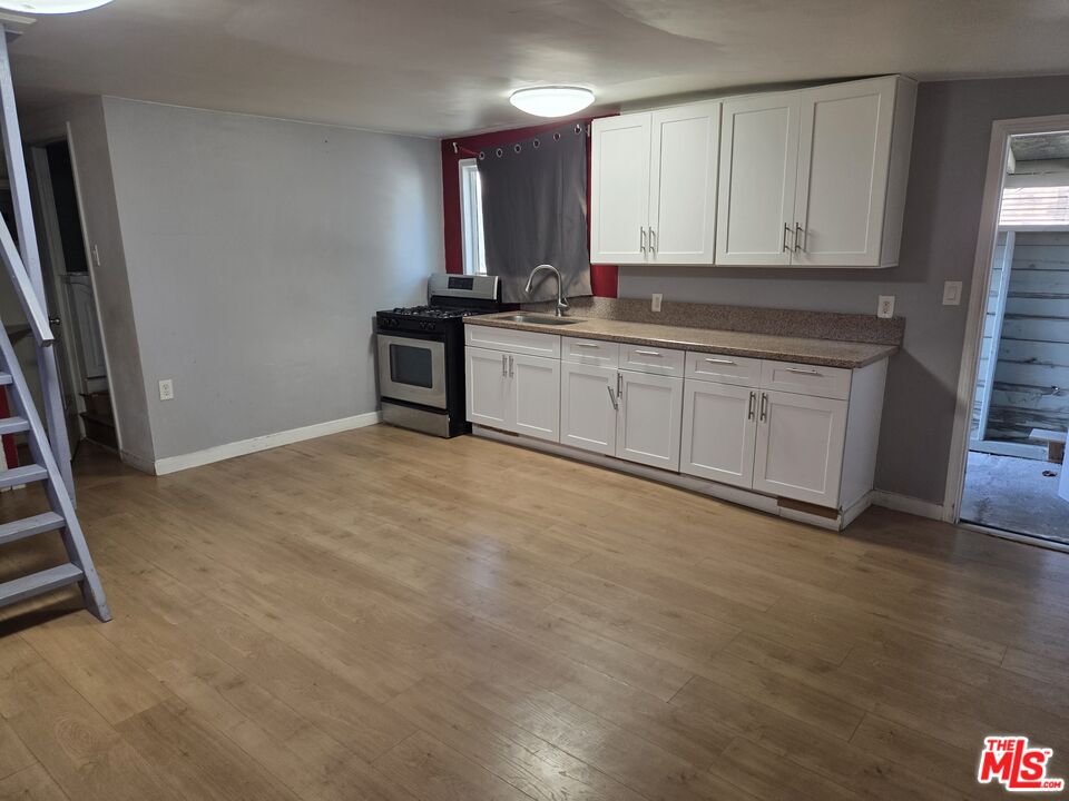 1612 Arlington Avenue Los Angeles, CA 90019 - Photo 23 of 24 a kitchen with stainless steel appliances granite countertop a stove a sink and a microwave