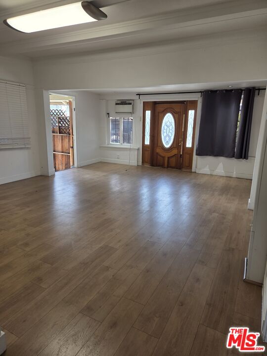 1612 Arlington Avenue Los Angeles, CA 90019 - Photo 5 of 24 a view of an empty room with window and wooden floor