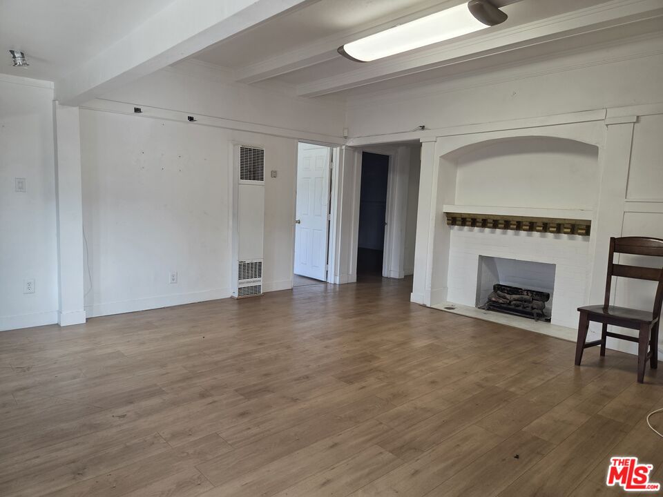 1612 Arlington Avenue Los Angeles, CA 90019 - Photo 6 of 24 a view of empty room with fireplace and wooden floor