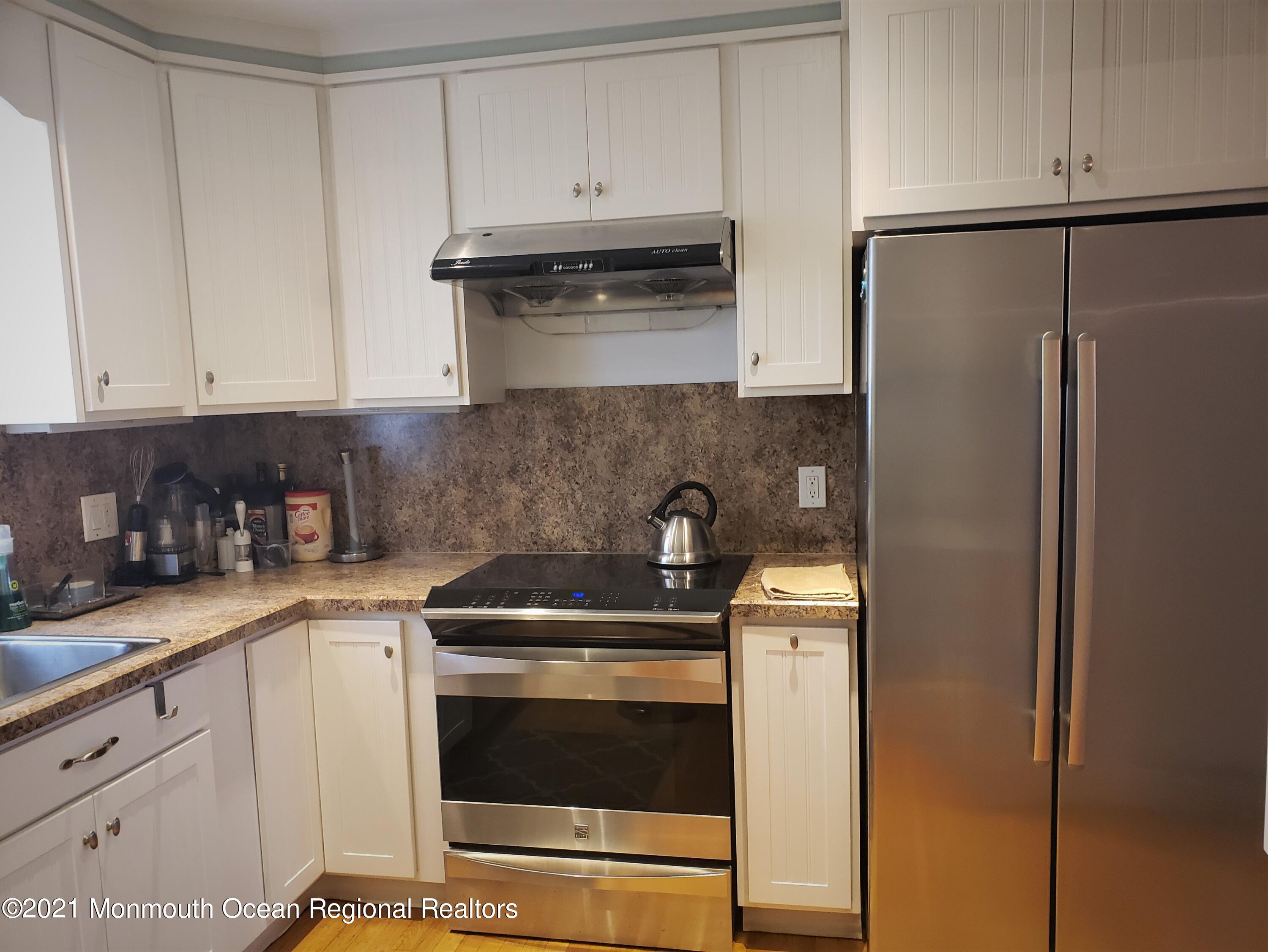 164 Linden Avenue, Unit 12 Highlands, NJ 07732 - Photo 4 of 8 a kitchen with stainless steel appliances granite countertop a refrigerator a stove a sink and white cabinets