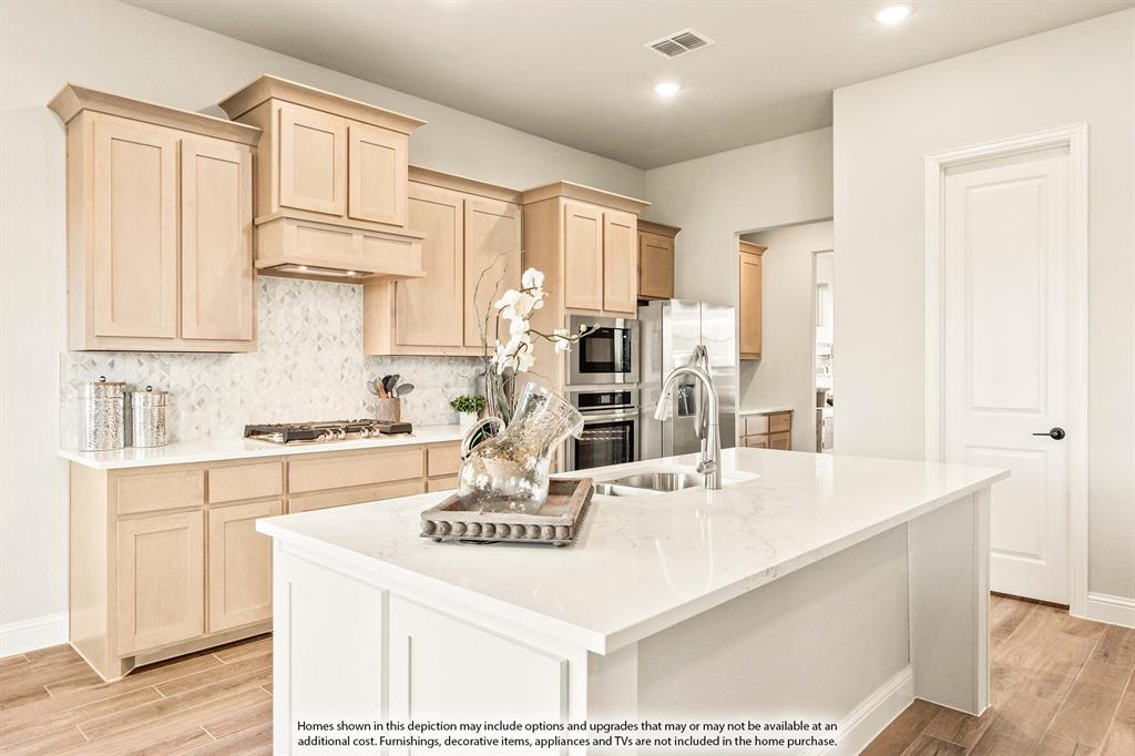 5422 Rutherford Drive Midlothian, TX 76065 - Photo 8 of 36 a kitchen with kitchen island granite countertop a stove a sink a refrigerator and white cabinets with wooden floor
