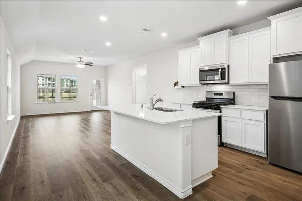 a kitchen with cabinets and wooden floor
