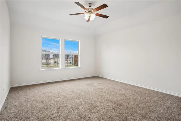 an empty room with windows and fan