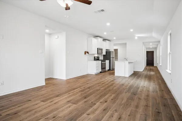 a view of kitchen with refrigerator stove and wooden floor