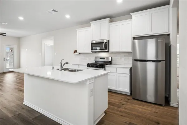 a kitchen with white cabinets and stainless steel appliances
