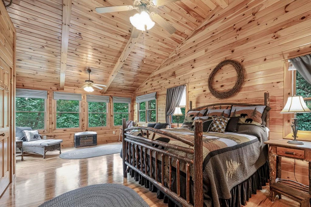 115 Lakota Trail Blue Ridge, GA 30513 - Photo 20 of 49 a bedroom with furniture a large window and a chandelier