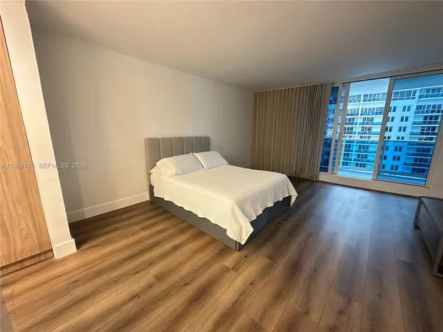 a bedroom with a bed and a large window