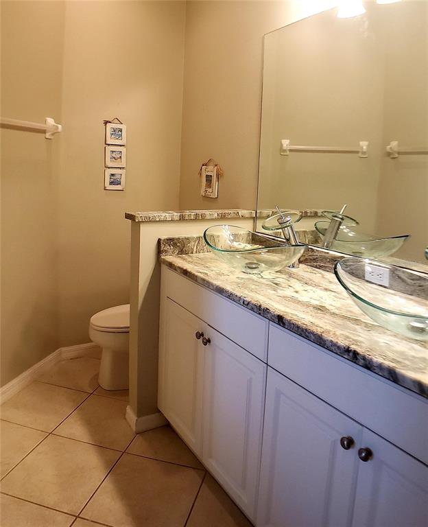 5662 Whitehead Street Bradenton, FL 34203 - Photo 34 of 51 a bathroom with a granite countertop sink a toilet and a mirror
