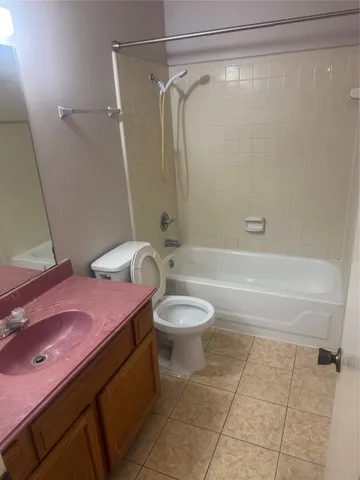 a bathroom with a granite countertop bathtub shower sink and toilet