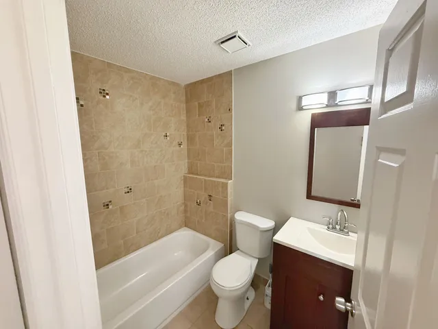 a bathroom with a sink a toilet and shower a mirror
