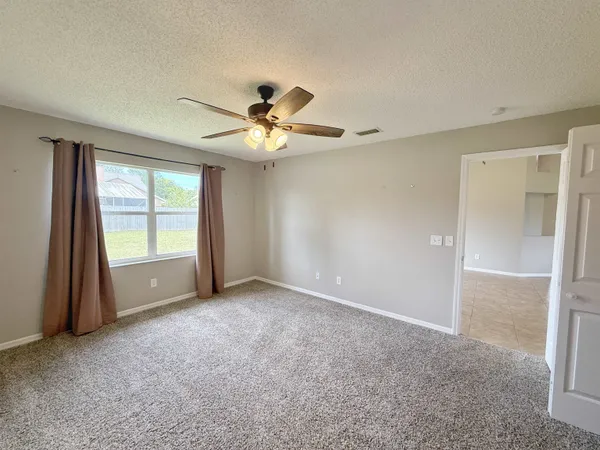 a view of a livingroom with a ceiling fan and window