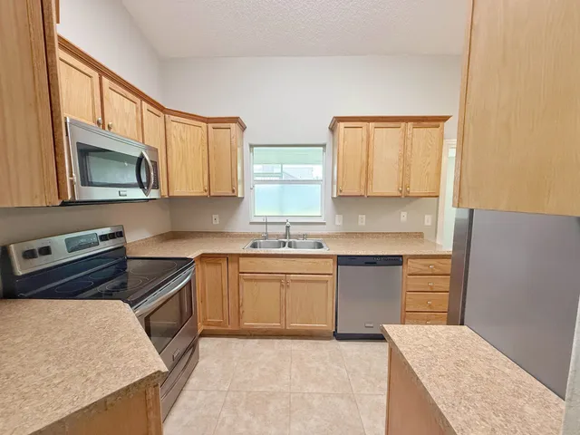 a kitchen with stainless steel appliances granite countertop a stove a sink and a microwave