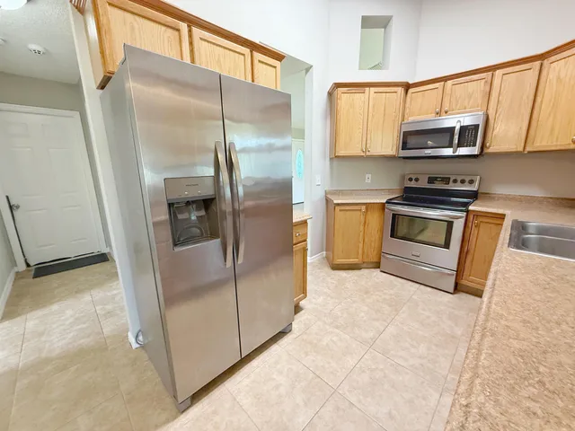 a kitchen with a refrigerator a microwave a sink and cabinets