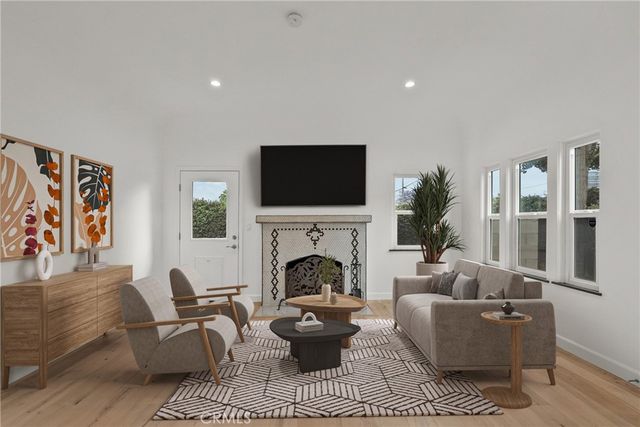 a living room with furniture a fireplace and a flat screen tv