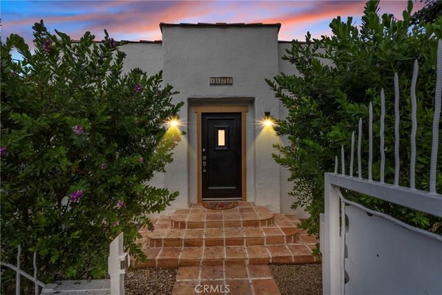 a front view of a house with a garden