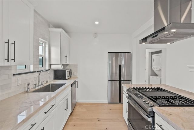 a kitchen with granite countertop a sink stove and refrigerator