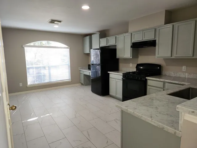 a kitchen with stainless steel appliances a stove a sink a microwave and refrigerator