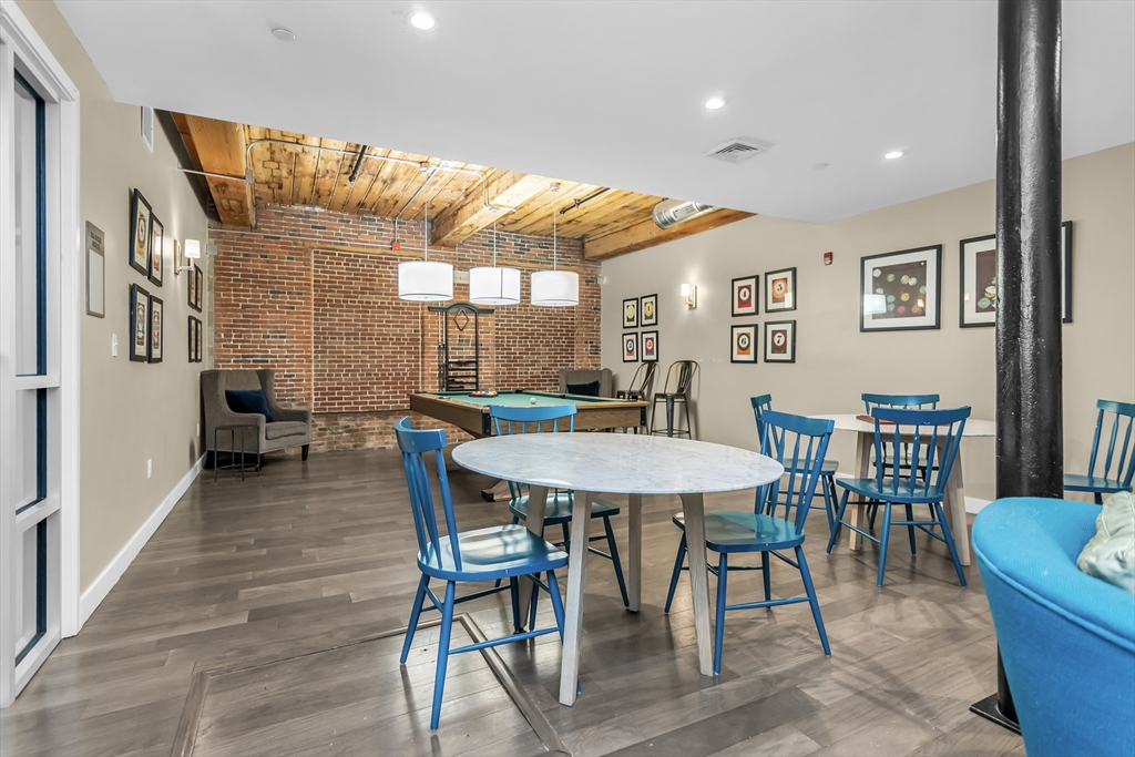 130 John Street, Unit 216 Lowell, MA 01852 - Photo 17 of 17 a view of a dining room with furniture and wooden floor
