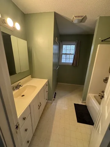 a bathroom with a double vanity sink and mirror with bathtub