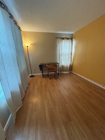 a view of a room with wooden floor and bench