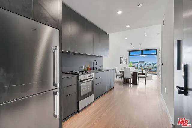 a kitchen with granite countertop stainless steel appliances a refrigerator and a stove top oven