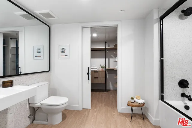 a bathroom with a toilet a sink a shower and mirror