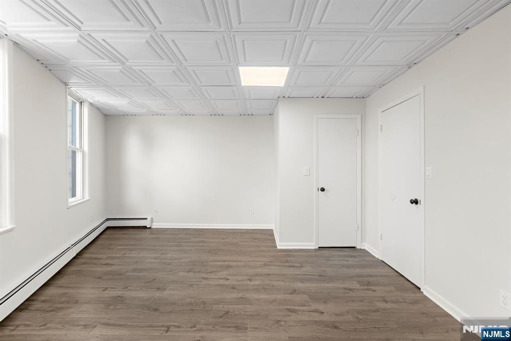 1534 Paterson Plank Road, Unit 2 Secaucus, NJ 07094 - Photo 11 of 17 a view of an empty room with wooden floor and a window