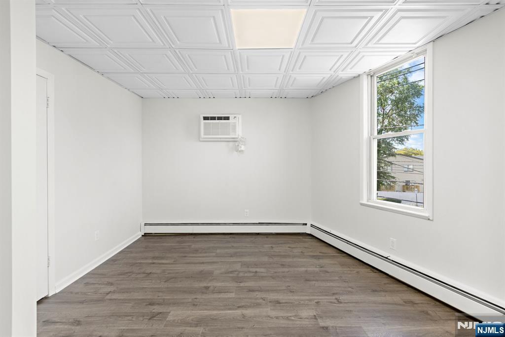 1534 Paterson Plank Road, Unit 2 Secaucus, NJ 07094 - Photo 13 of 17 an empty room with wooden floor and windows