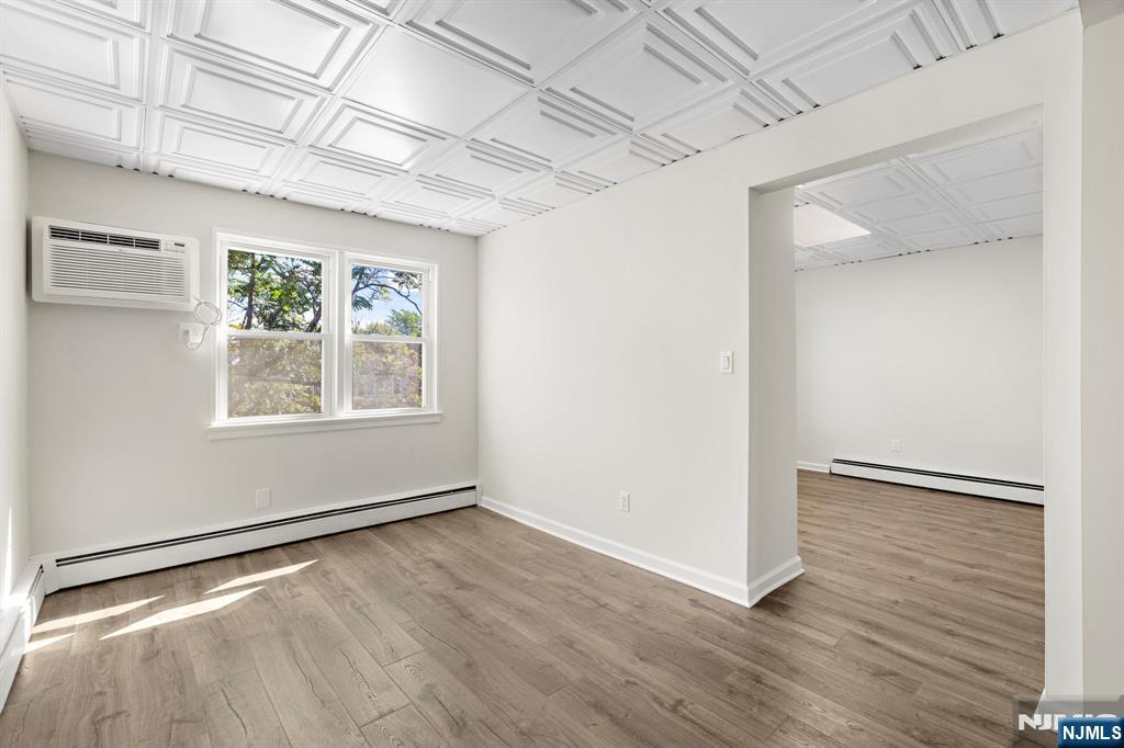 1534 Paterson Plank Road, Unit 2 Secaucus, NJ 07094 - Photo 3 of 17 a view of an empty room with wooden floor and a window