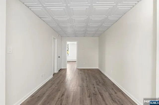 a view of a room with wooden floor and white walls